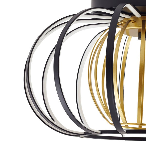 Nahaufnahme einer modernen LED-Deckenleuchte mit geschwungenen Metallbändern in Schwarz und Gold sowie integrierten LED-Streifen.