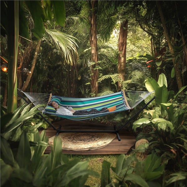 Frau entspannt in Hängematte mit Gestell im Garten.