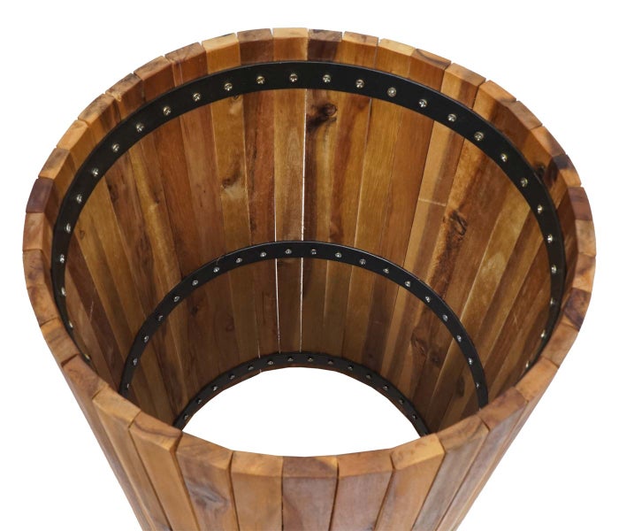 Blick in einen runden Pflanzkübel aus vertikalen Holzlatten, die mit schwarzen Metallringen und Schrauben fixiert sind.