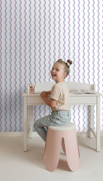 Szene eines Kinderzimmers mit Schreibtisch, Hocker und Tapete mit Wellenmuster