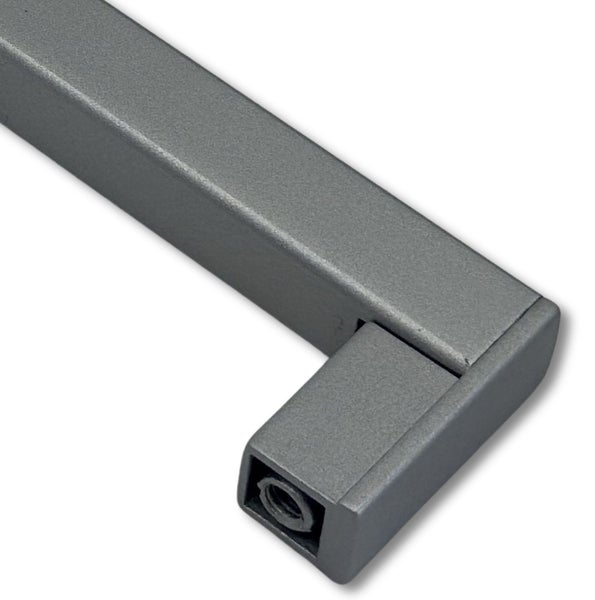 Ein quadratischer Möbelgriff aus Metall mit matter Oberfläche und integrierter Gewindebohrung für die Montage an Schranktüren oder Schubladen.