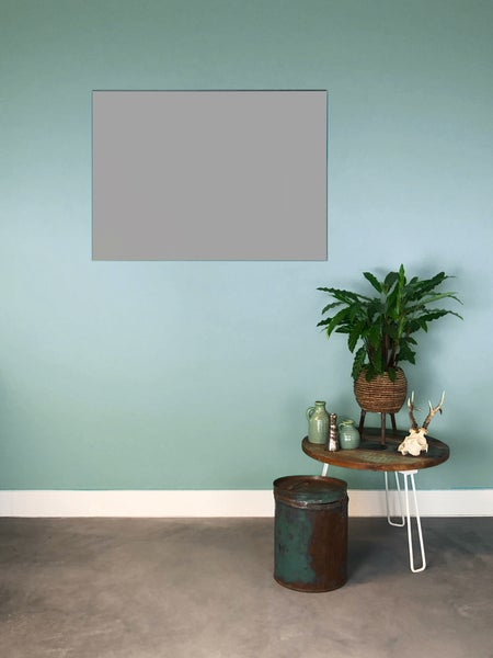 Einrichtungsbeispiel mit mintgrüner Wandfarbe, kleinem Holztisch und Zimmerpflanze vor einem grauen Farbfeld.