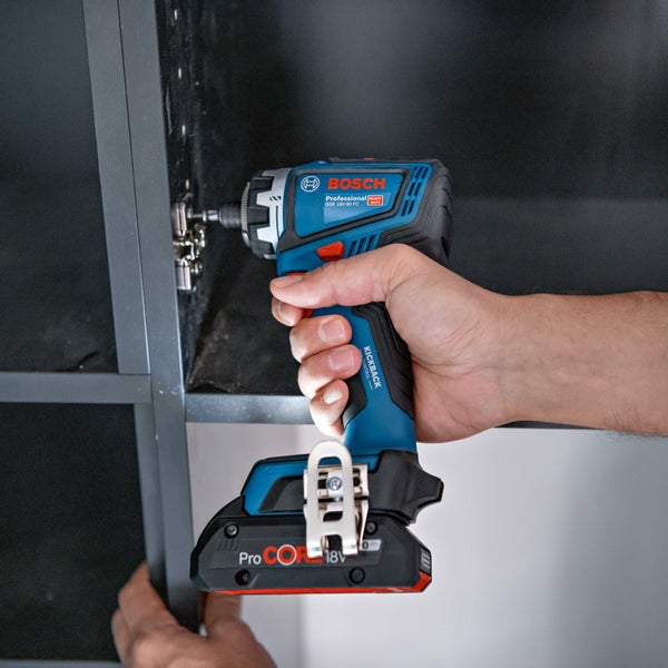 Ein Mann montiert mit einem Akku-Schlagschrauber ein Regal.