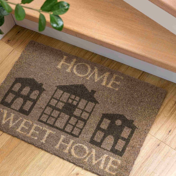 Fußmatte mit dem Aufdruck Home Sweet Home und Hausmotiven vor einer Treppe
