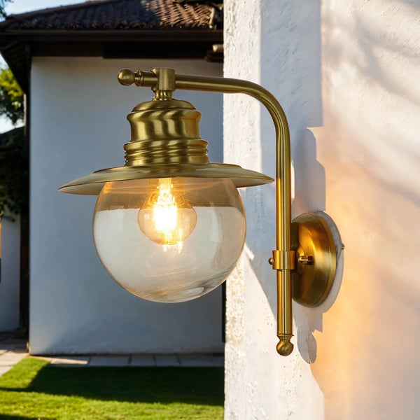 Goldene Außenwandleuchte mit Kugelglas und Halterung an einer Wand