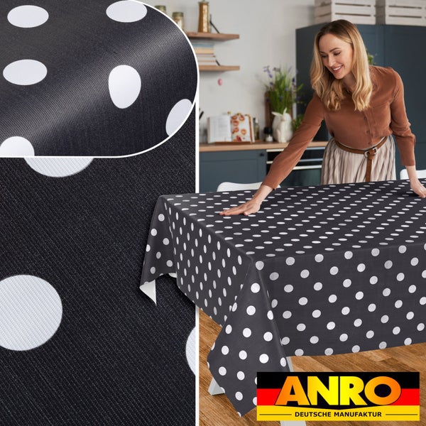 Abwaschbare Tischdecke mit weißen Punkten auf schwarzem Grund in einer Küche. Detailansicht der Materialstruktur und ANRO Logo.