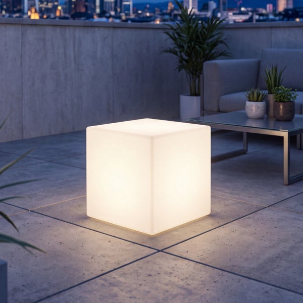 Beleuchteter Sitzwürfel als Gartenleuchte aus Kunststoff auf einer modernen Dachterrasse bei Dämmerung.