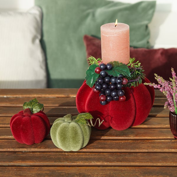 Dekorative Anordnung mit Kürbissen und Kerze auf einem Holztisch