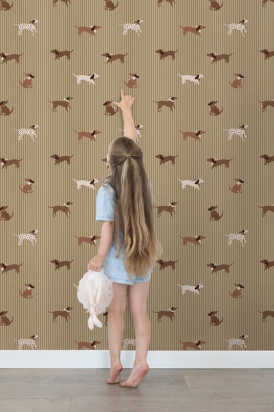 Mädchen vor Tapete mit Dackelmotiven und Streifen