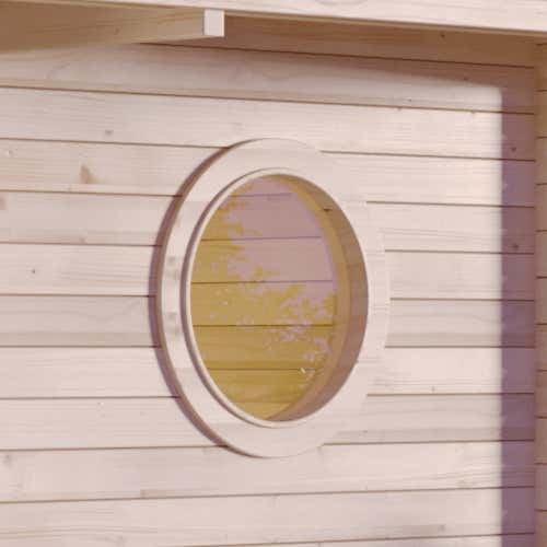 Rundfenster in einer Holzwand eines Gartenhauses aus hellem Holz.