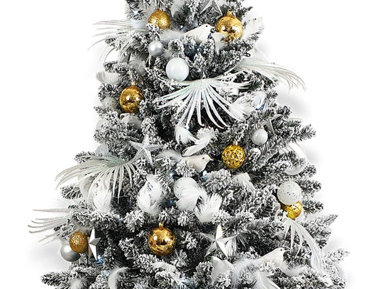Ein künstlicher, verschneiter Weihnachtsbaum, geschmückt mit Kugeln, Sternen, Federn und Vogeldekorationen.