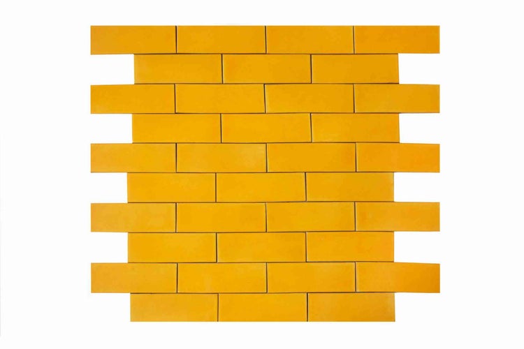 Gelbe Mosaikfliesen in Rechteckform und Backstein-Optik für die Wand.