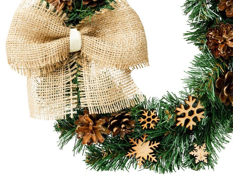 Weihnachtskranz aus künstlichen Tannenzweigen mit Juteschleife, Tannenzapfen und Holzschneeflocken als Weihnachtsdekoration.
