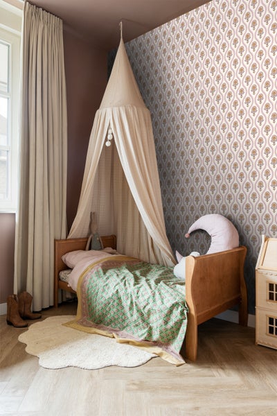 Kinderzimmer mit Himmelbett, gemusterter Tapete und dekorativen Accessoires für ein gemütliches Ambiente