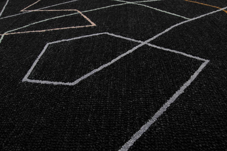 Nahaufnahme eines Teppichs mit Kurzflor und geometrischem Linienmuster.