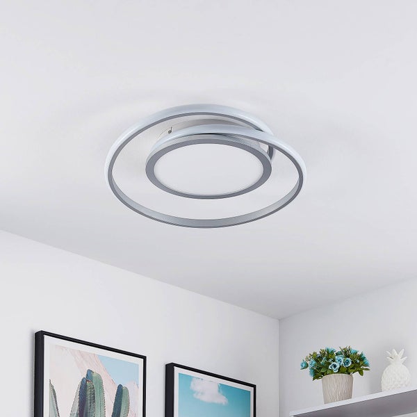 Moderne LED-Deckenleuchte im Ringdesign mit zwei ineinander verschlungenen Kreisen, montiert an einer Zimmerdecke.