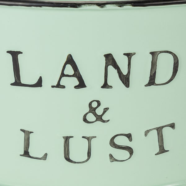 Detailansicht eines Metallgefäßes mit dem Schriftzug LAND und LUST.