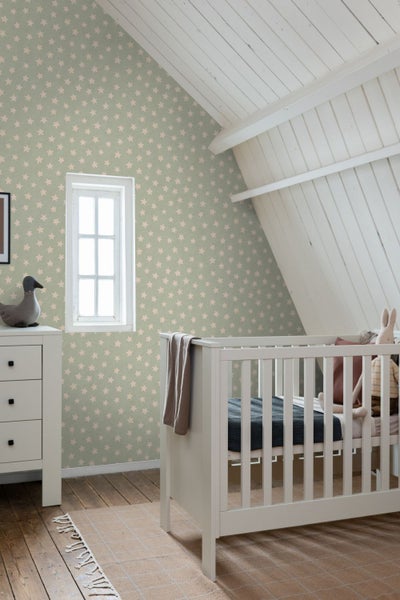 Kinderzimmer mit Babybett, Kommode und Sternentapete