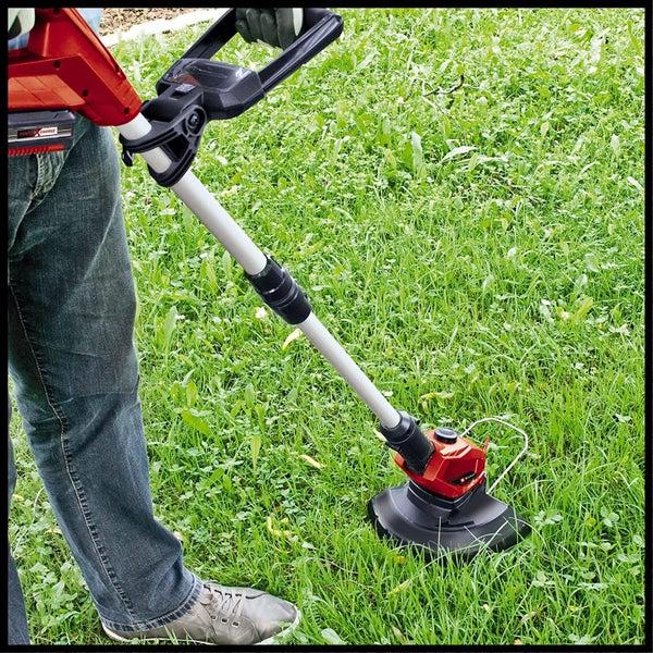 Person verwendet einen akkubetriebenen Rasentrimmer für Gartenarbeiten auf einer Rasenfläche