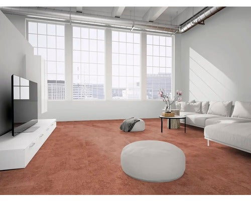Heller Wohnraum im modernen Industrial-Stil mit terracotta-farbenem Boden, großen Fenstern, weißem Ecksofa und minimalistischen Möbeln.