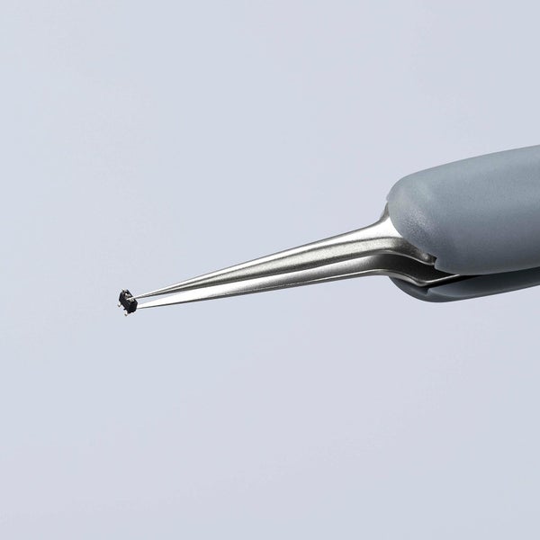 Pinzette, die ein elektronisches Bauteil hält