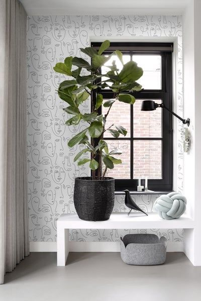 Helle Inneneinrichtung mit Fenster, Zimmerpflanze, Dekoration und gemusterter Tapete