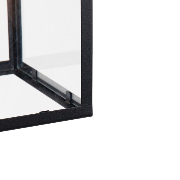 Nahaufnahme der unteren Ecke einer schwarzen Metalllaterne mit klaren Glasscheiben.