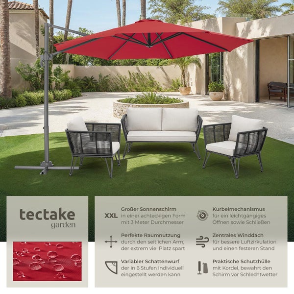Gartenszene mit rotem Sonnenschirm, zwei Sesseln und einem Sofa mit hellen Polstern