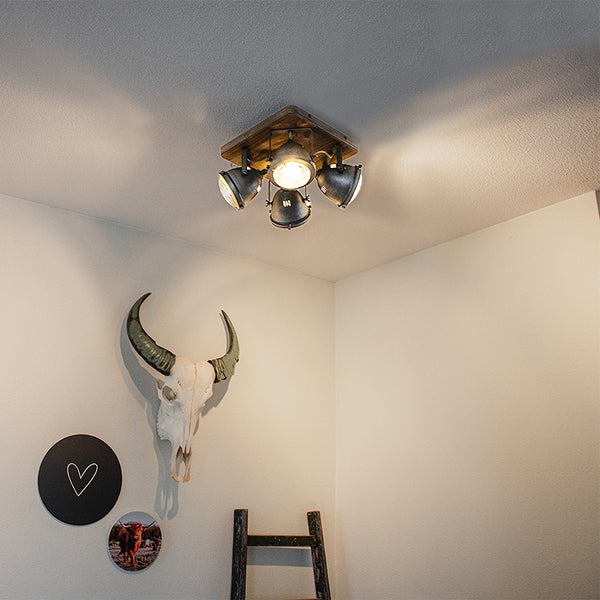 Deckenleuchte mit vier Strahlern und Holzsockel in einem hellen Raum