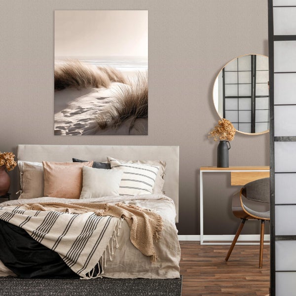 Modernes Schlafzimmer mit Doppelbett, Wandbild mit Dünenlandschaft, rundem Spiegel und Konsolentisch im wohnlichen Design.