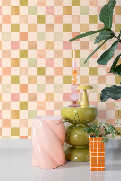 Szene mit dekorativen Elementen vor einer karierten Tapete