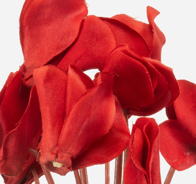 Rote künstliche Alpenveilchen aus Textilgewebe in der Detailansicht.