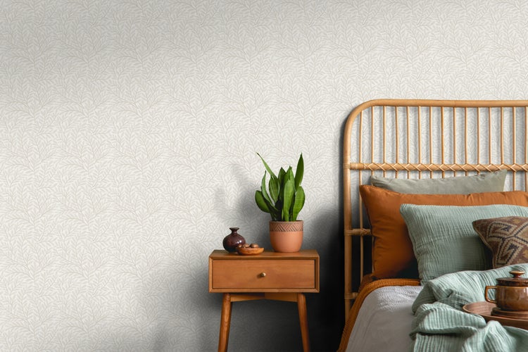 Schlafzimmer mit Bett, Nachttisch und Tapete mit Blättermotiv