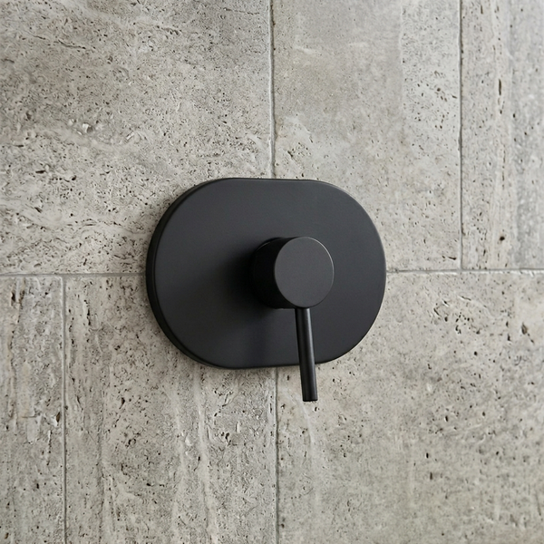 Matte schwarze Unterputz-Duscharmatur mit ovaler Grundplatte und Einhandmischer auf einer strukturierten Wand.