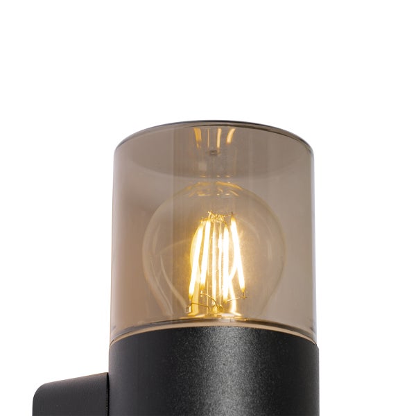 Wandleuchte mit schwarzem zylindrischem Sockel, Rauchglas-Schirm und LED-Filament-Leuchtmittel.