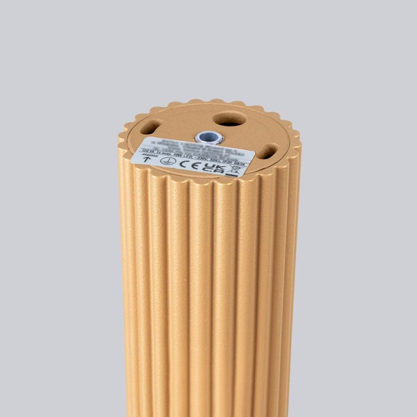 Goldfarbene Stehleuchte mit Rillenmuster.