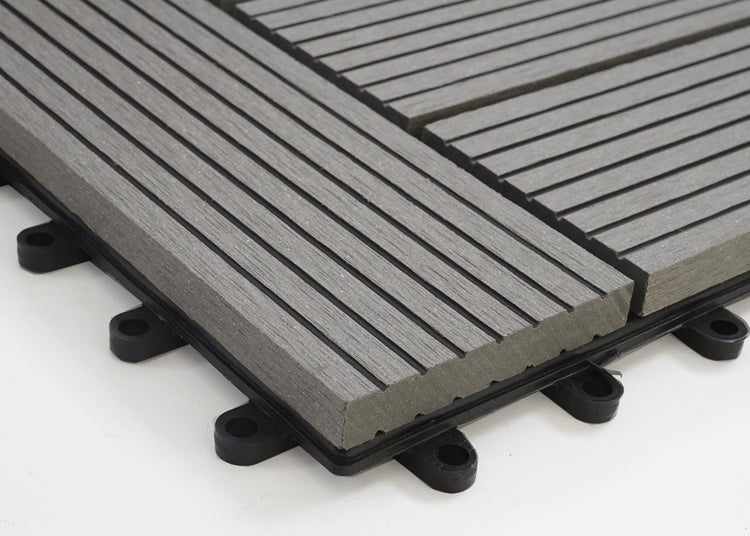 Graue Terrassenfliese aus Holz-Kunststoff-Verbundwerkstoff mit geriffelter Oberfläche und schwarzem Klick-System aus Kunststoff.