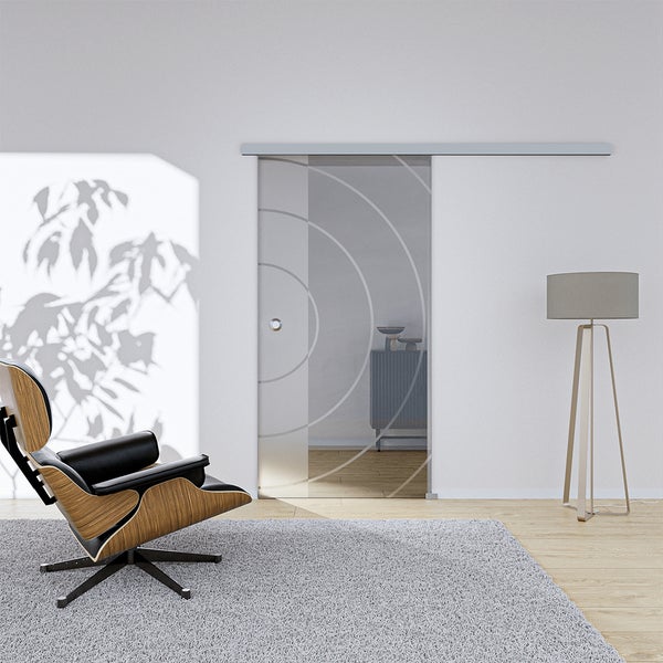 Schiebetür aus Glas mit kreisförmigem Dekor in einem hellen Wohnraum.