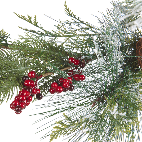 Künstlicher Tannenzweig mit roten Beeren und Schneeeffekt für die Weihnachtsdekoration.