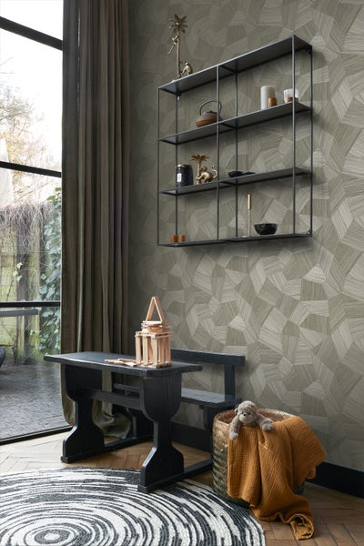 Wohnraum mit grafischer Tapete, schwarzem Regal, Kindertischgruppe und rundem Teppich