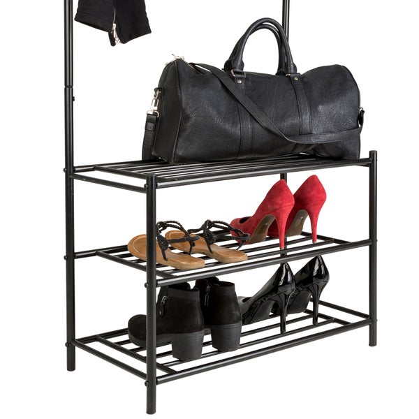 Schwarzes Schuhregal aus Metall mit drei Ebenen, befüllt mit einer Reisetasche, Sandalen, Pumps und Stiefeletten.