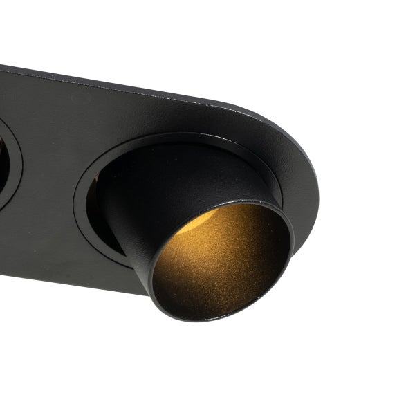 Detailansicht eines schwarzen zylindrischen Strahlers in einer Halterung mit warmem Licht.