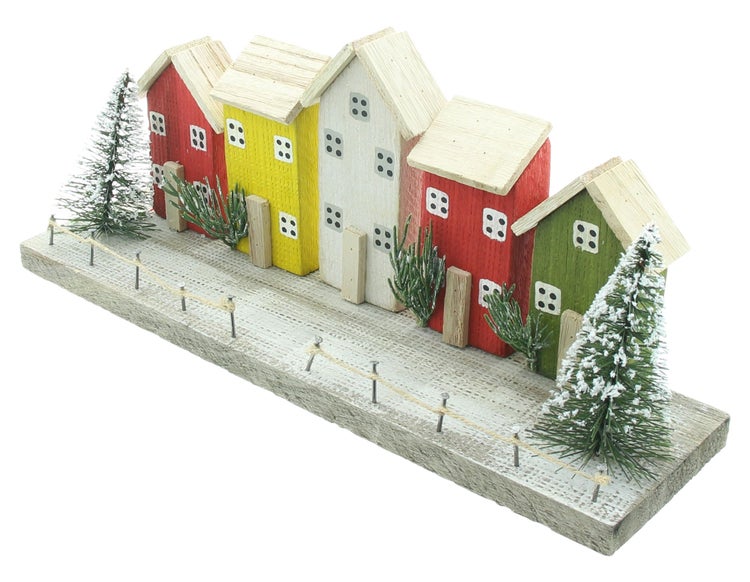 Dekorative Holzhausreihe mit Bäumen und Zaun als Weihnachtsdekoration