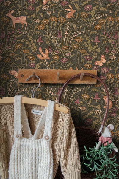 Vliestapete mit Wald- und Wiesenmotiven wie Rehen, Hasen und Blumen in einem Kinderzimmer.
