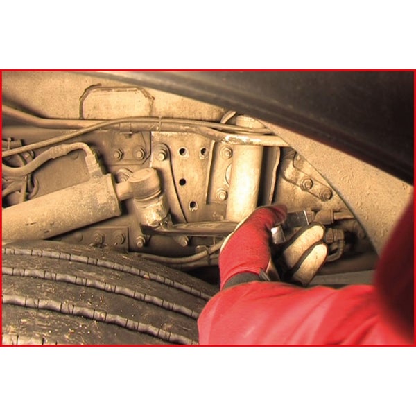 Nahaufnahme eines Reifens und der Aufhängung eines Fahrzeugs während der Reparatur durch eine Person mit Schraubenschlüssel