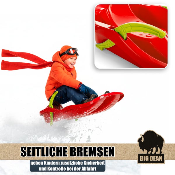 Kind zieht einen Kunststoffschlitten mit Zugseil durch eine verschneite Winterlandschaft im Wald. Big Dean Logo.
