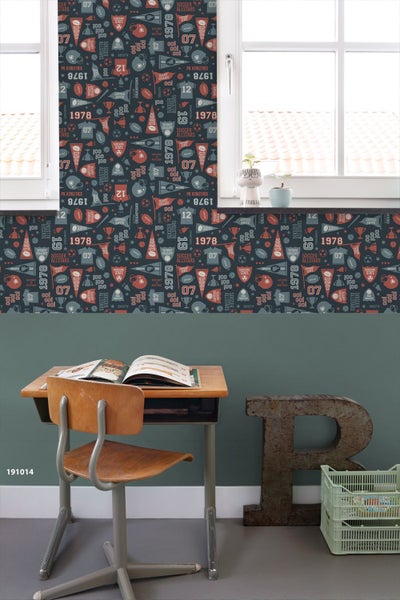 Zimmer mit einer Wandtapete mit Sportmotiven, einem Schreibtisch und einem Fenster