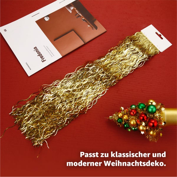 Goldene Lametta Girlande neben Zeitschrift auf rotem Hintergrund