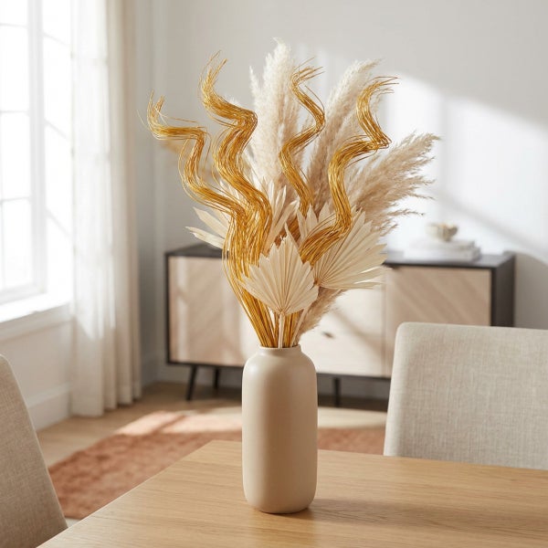 Dekorative Trockenblumen mit gewundenen Zweigen und Palmblättern in einer schlichten Vase auf einem Holztisch.