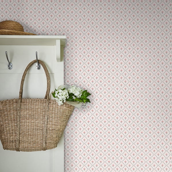 Tapete mit floralem Rautenmuster im Landhausstil mit Garderobe, Strohtasche und Blumenstrauß an der Wand.